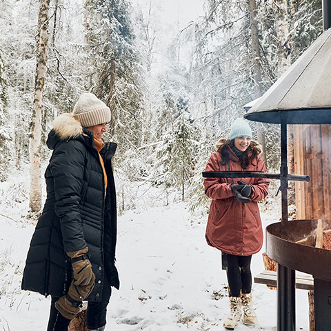 Two people next to an outside fireplace