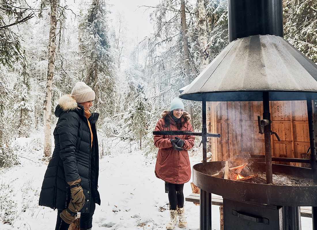 Two people next to an outside fireplace