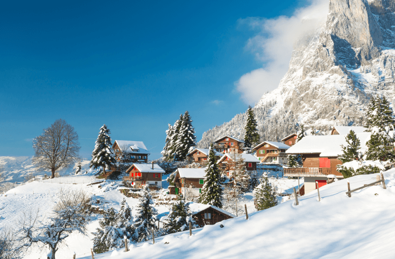 snowy village with mountains in the background