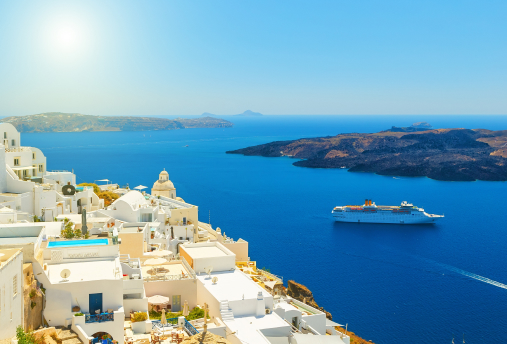 A cruise ship sailing past a Mediterranean coastal town.