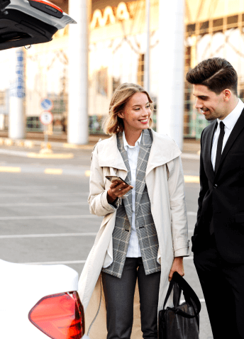 Two people talking in a parking lot in front of a car