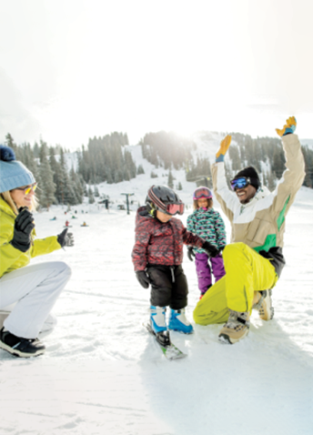 Two adults and two children playing in the snow